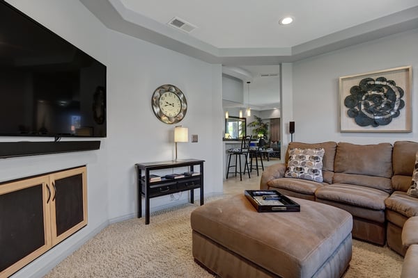 Sink into your plush leather sofa and unwind in this welcoming living space. Modern comfort meets warmth with a cozy fireplace, stylish accents, and tray-ceilinged serenity perfect for your downtime.