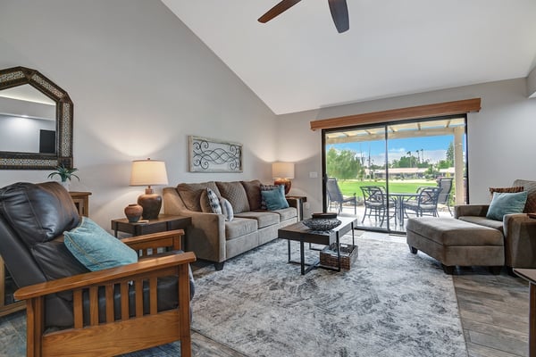 Unwind in your spacious living room where vaulted ceilings and plush furnishings create an inviting retreat. Step through the sliding glass doors to your private patio overlooking the lush green fairways.