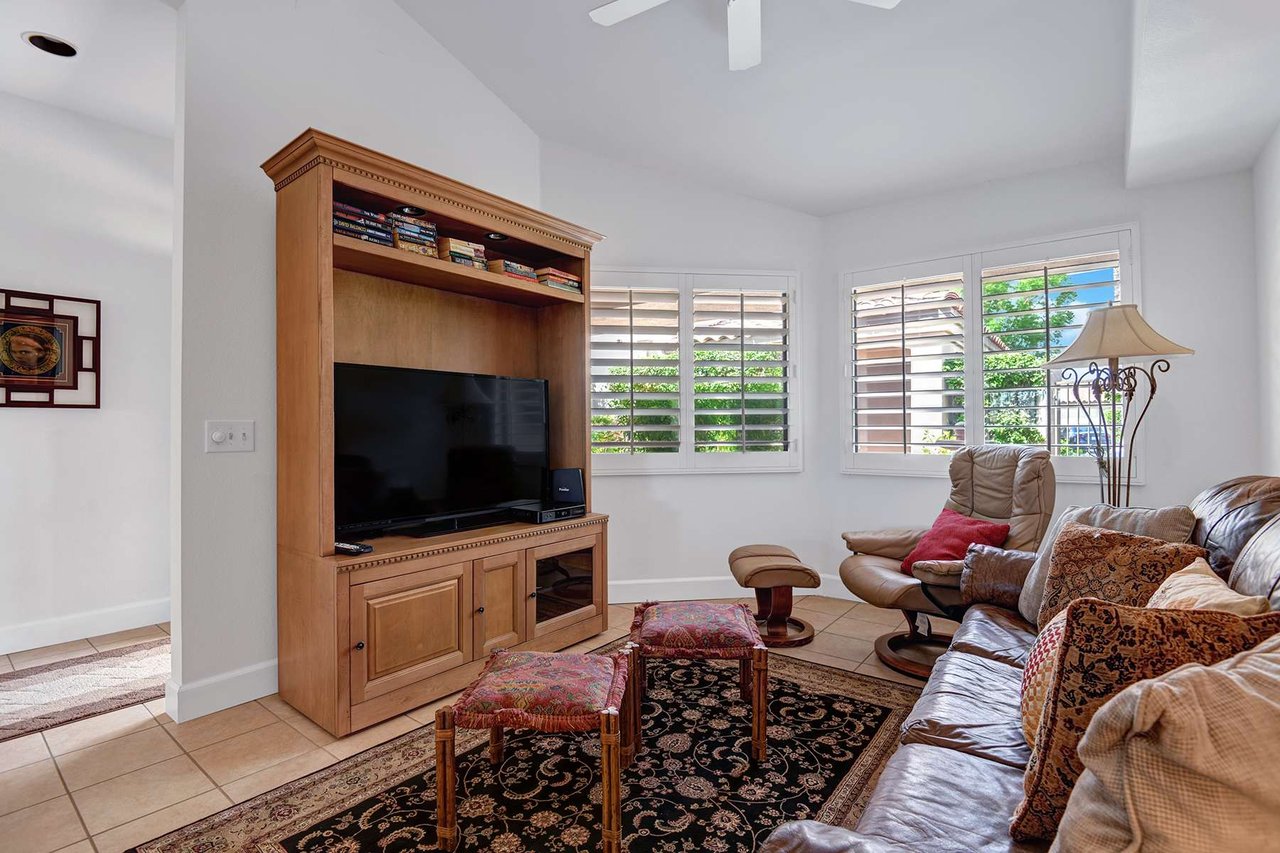 Sink into plush seating and unwind in your comfortable living space, where sunlight filters through plantation shutters and entertainment awaits.