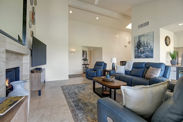 Settle into your spacious living room where modern comfort meets warm desert style. A cozy fireplace and high ceilings create the perfect retreat after a day of adventure.