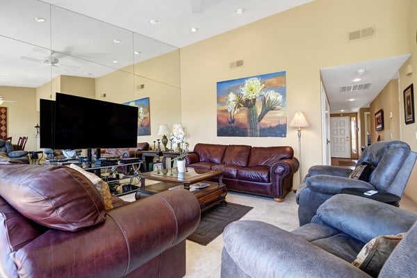 Sink into plush leather seating and unwind in your spacious living room, where mirrored walls and warm desert tones create a bright, relaxing atmosphere for your stay.