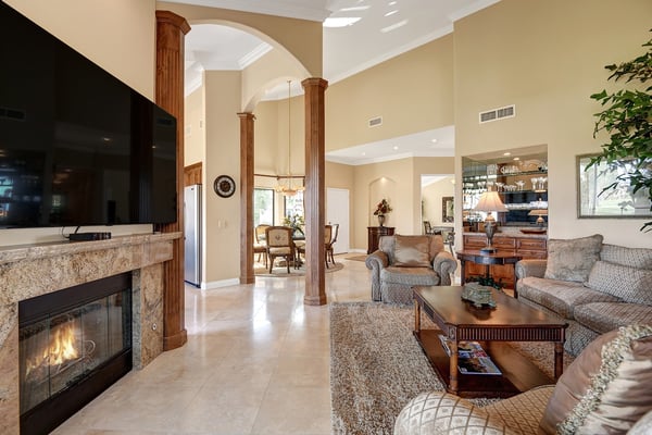 Sink into plush seating in this elegant living space where soaring ceilings and warm firelight create the perfect retreat after your desert adventures.