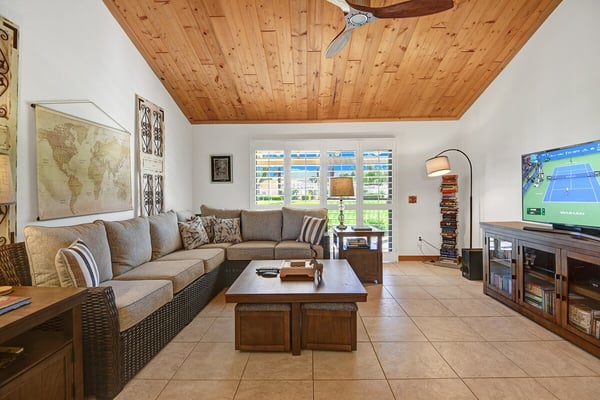 Sink into the plush sectional and unwind beneath the warm wood-planked ceiling. Natural light pours through plantation shutters, while your favorite shows await on the entertainment center.