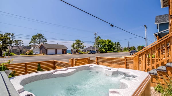 Soak in the bubbling hot tub and enjoy glimpses of the ocean just beyond the neighborhood—your perfect coastal escape awaits.