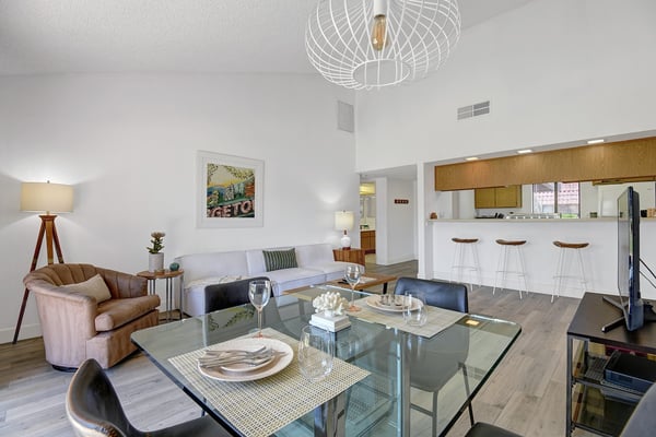 Step into an open, light-filled living space where vaulted ceilings and modern design invite you to unwind. Your living room flows effortlessly into a sleek kitchen with a breakfast bar, perfect for morning coffee or evening cocktails.