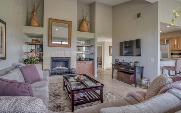 Settle into your inviting living room where soaring ceilings and a cozy fireplace create the perfect atmosphere for relaxation. Plush seating and warm finishes make this your home away from home.