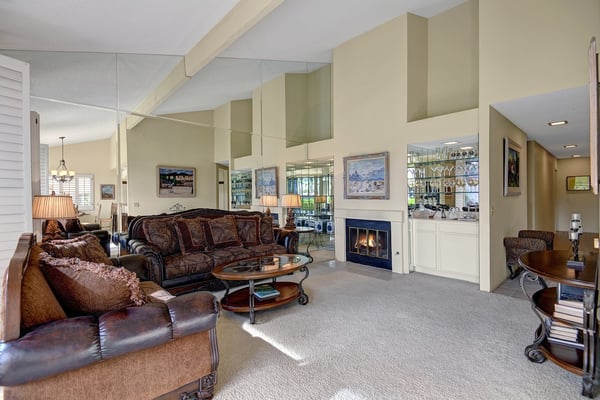 Sink into plush sofas by the warming fireplace while vaulted ceilings and mirrors create an airy, open feel. Your perfect gathering spot awaits.