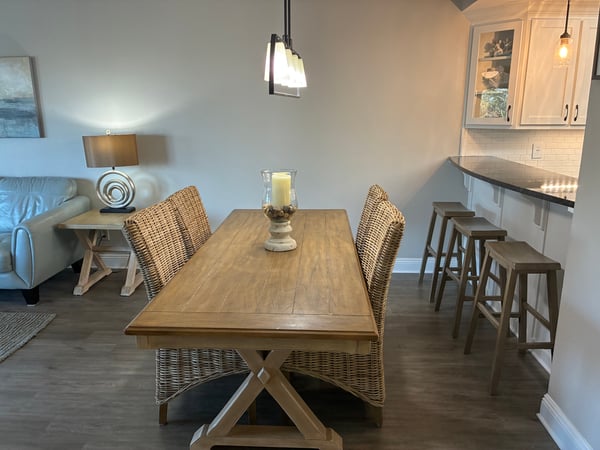 Gather around the beautiful wooden dining table for leisurely meals, with warm pendant lighting overhead and a cozy breakfast bar nearby—perfect for your group to reconnect and relax together.