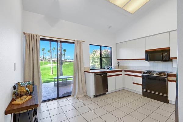 Your fully equipped kitchen opens directly onto a patio where palm trees and manicured greens create a peaceful backdrop. Cook, dine, and step outside to soak in the resort-like atmosphere.