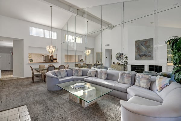 Settle into this light-filled living space where soaring ceilings and elegant design invite you to unwind. Soft seating, warm lighting, and thoughtful touches make it your perfect retreat after a day of exploring.