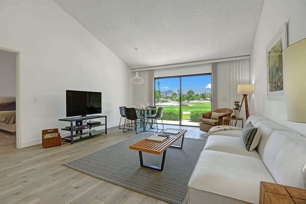 Relax in your bright, open living space with mountain views framed by sliding glass doors. Sink into the plush sofa, gather at the dining table, or step outside to enjoy the fresh air and lush greenery.