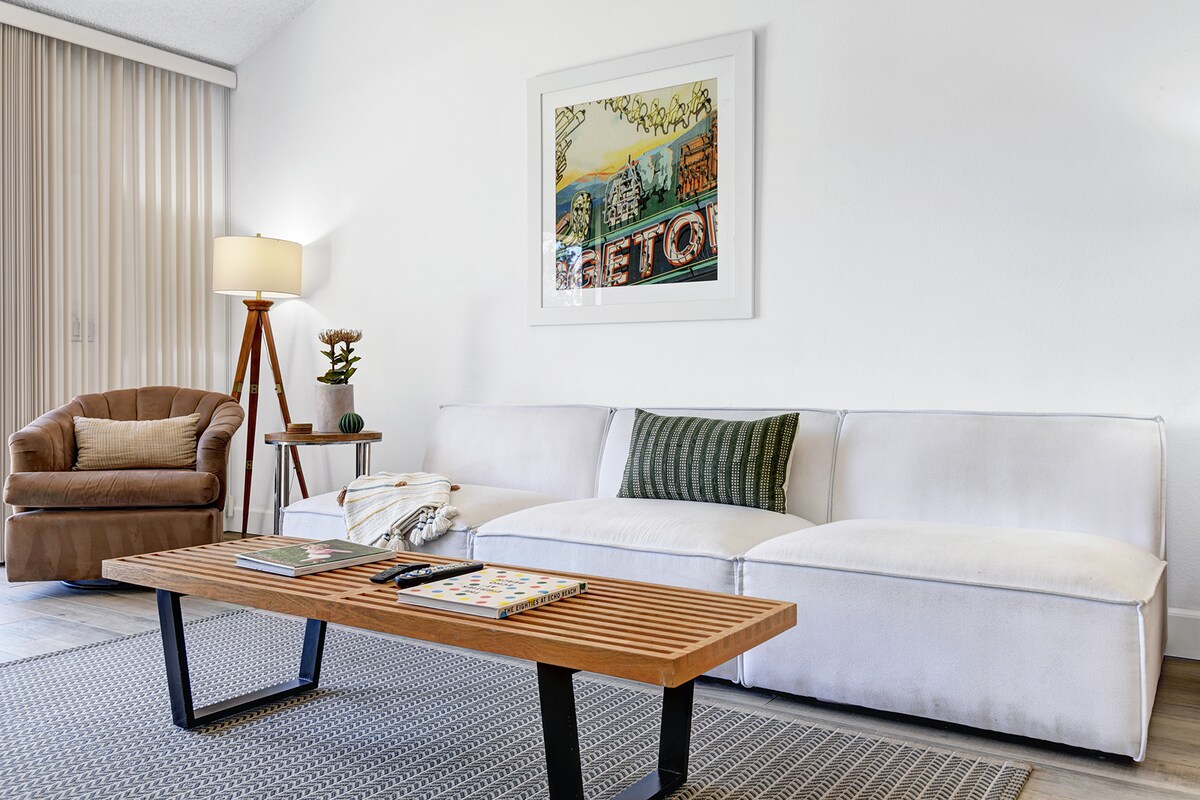Sink into the plush white sofa and unwind in your bright, airy living room—a calming retreat designed for your relaxation, complete with stylish furnishings and charming touches throughout.