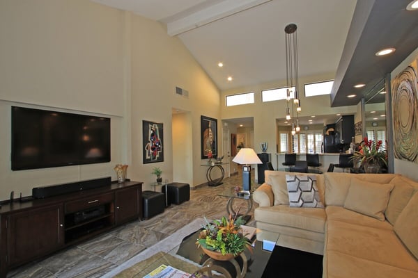 Settle into your stylish living room with vaulted ceilings and modern decor. The open layout flows seamlessly to the kitchen, creating a bright, inviting space where you'll love to unwind after exploring.