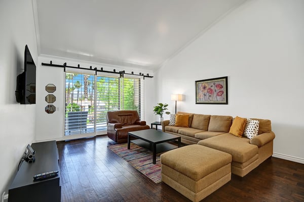 Settle into this bright living space where natural light streams through plantation shutters. Your comfortable sectional awaits, perfect for relaxing after a day of exploring.