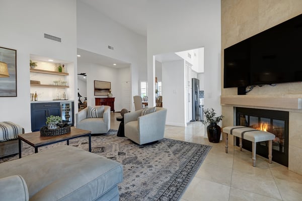 You'll love gathering around the glowing fireplace and plush seating in this bright, open living space. High ceilings, travertine flooring, and elegant built-ins create a welcoming atmosphere for unforgettable vacation moments.